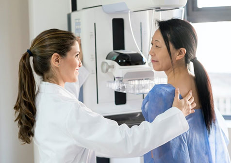 Radiologist performing three-dimensional (3D) mammography, or digital breast tomosynthesis, on a patient